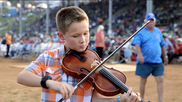 photograph of Carson Peters playing fiddle at the annual Old Fiddlers’ Convention in Galax, Virginia
