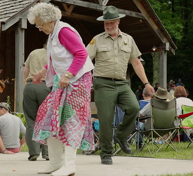 photograph of a ranger and other folk festival participants dancing at the annual Old Fiddlers’ Convention in Galax, Virginia